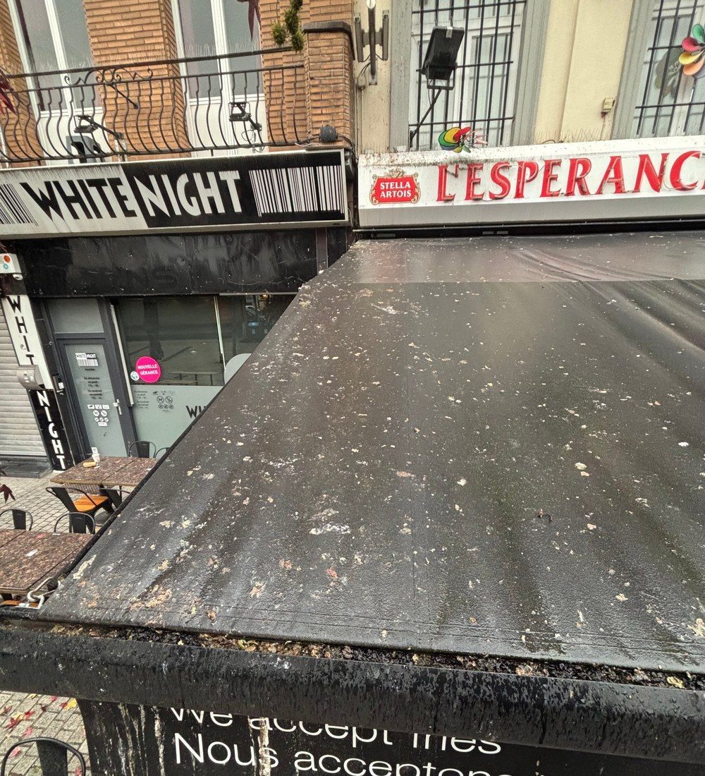 Bâche de terrasse noire couverte de fientes avant nettoyage