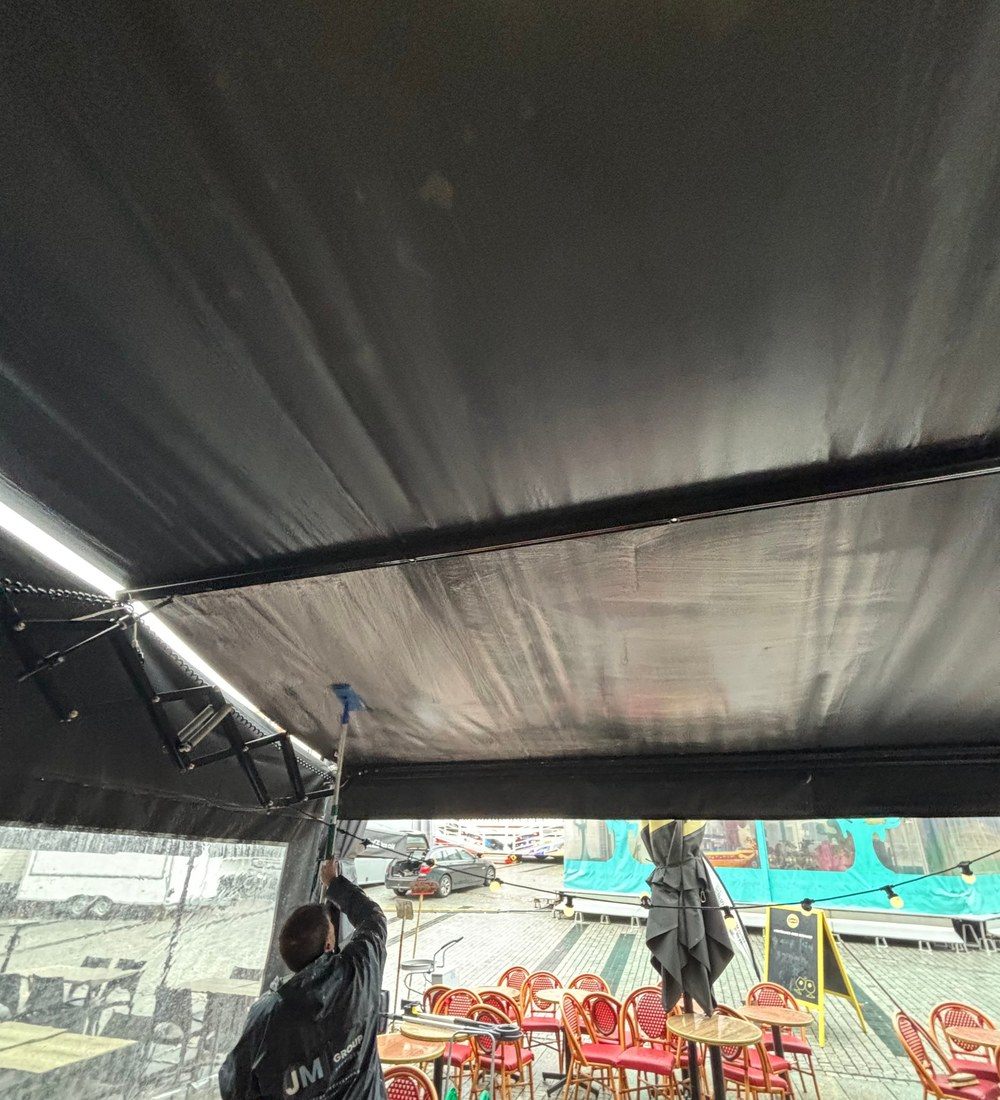 Agent JM Group nettoyant la sous-face d'une bâche de terrasse